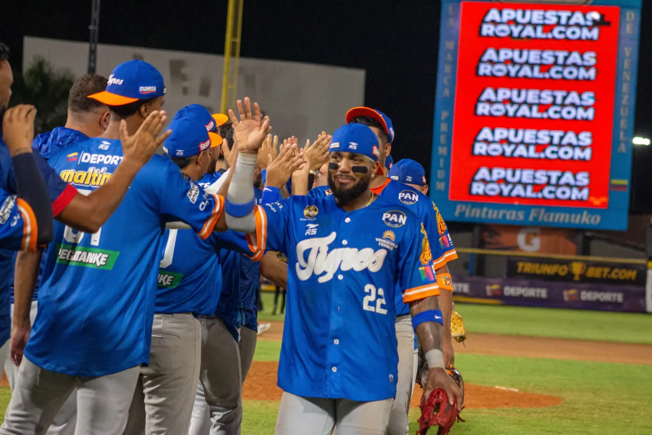 Peloteros de Tigres de Aragua celebran con choques de manos en el terreno tras la victoria ante Magallanes