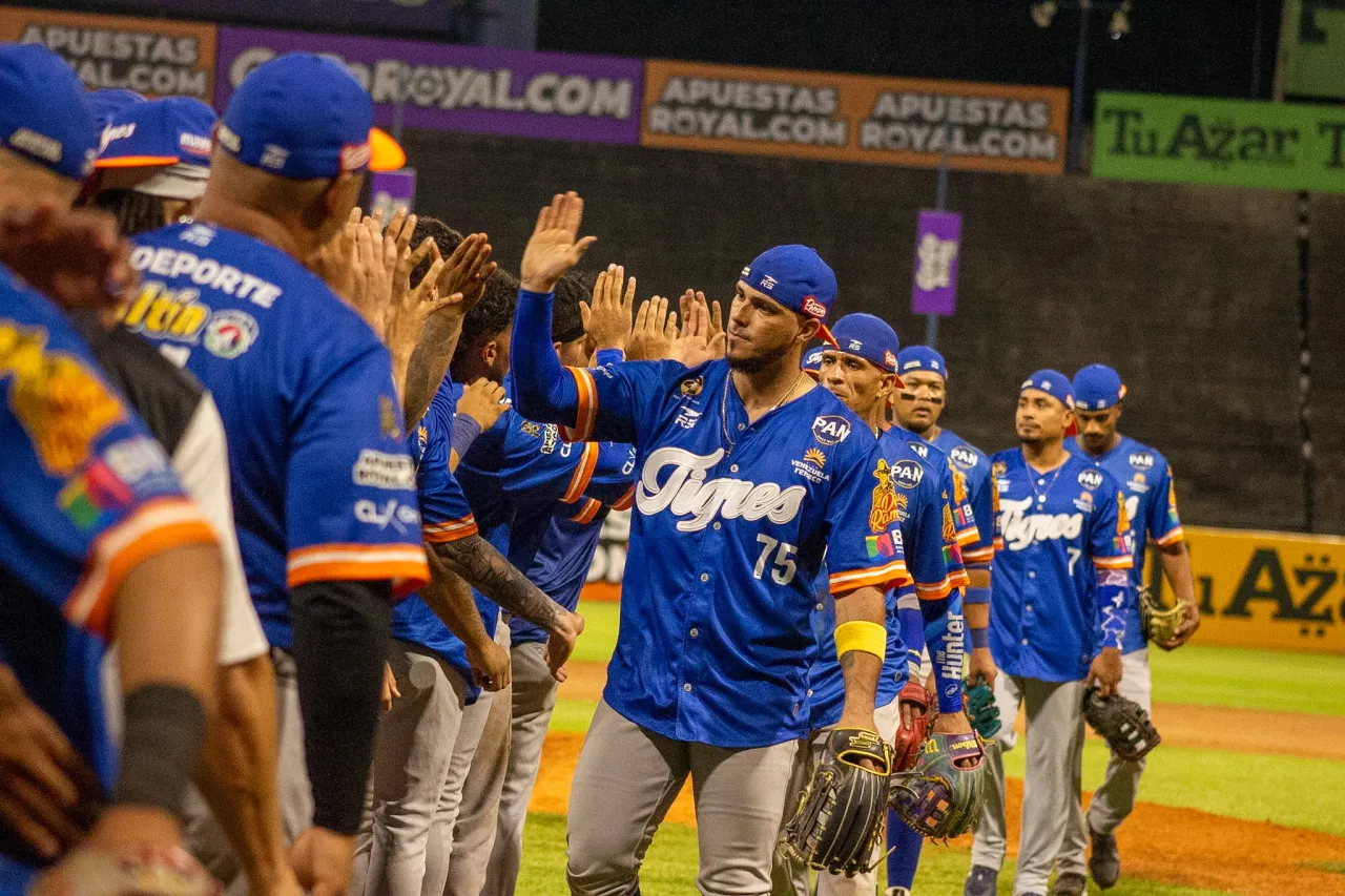 Peloteros de Tigres de Aragua se saludan con choques de manos en el terreno tras la victoria en el Universitario